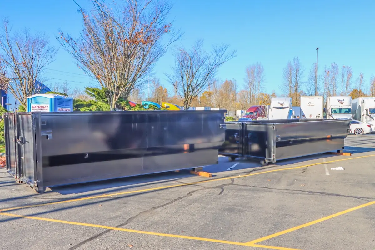 Professional dumpster rental service with roll-off container on residential driveway in Keyport